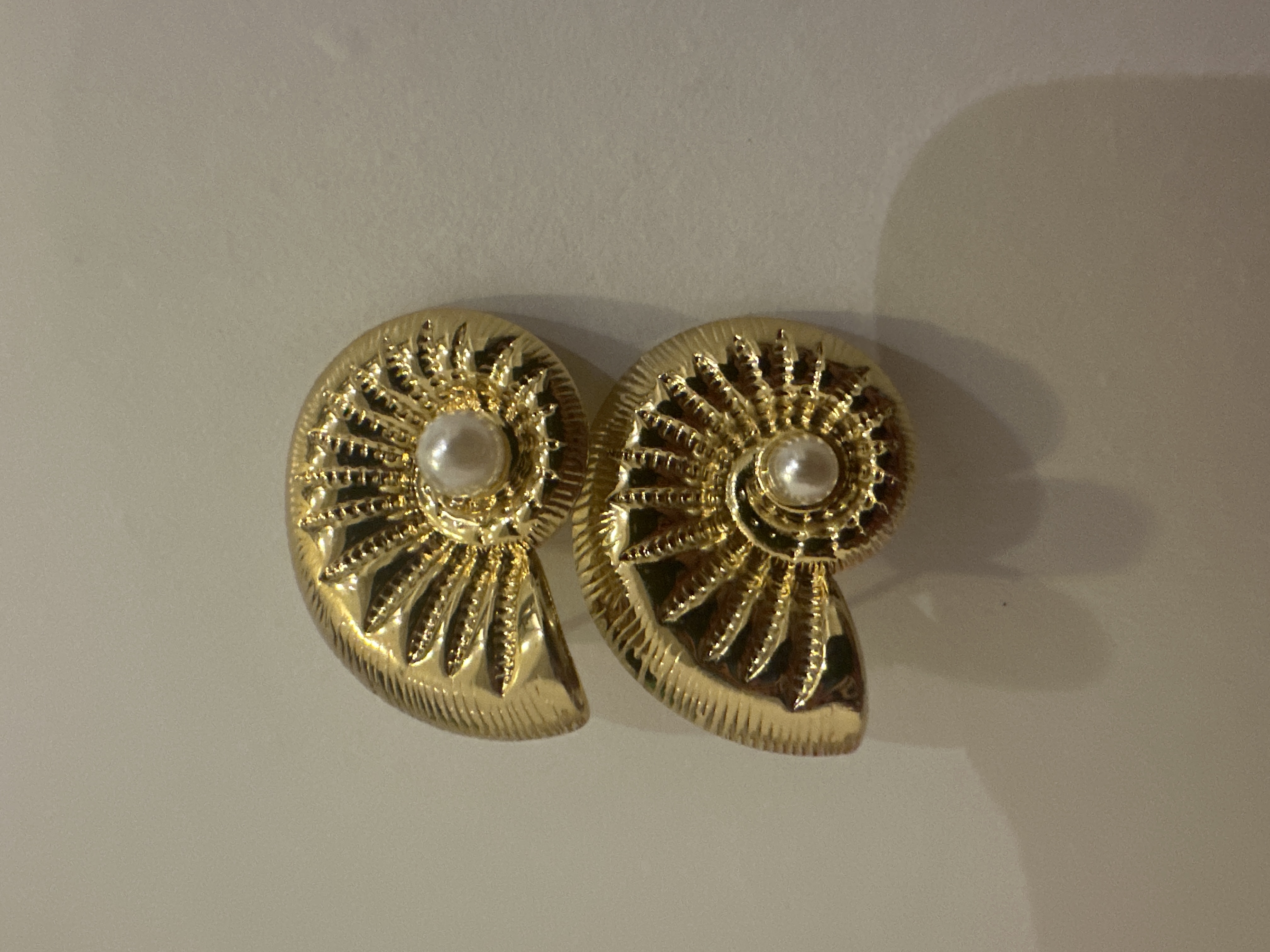 Aretes dorados caracol con perla blanca